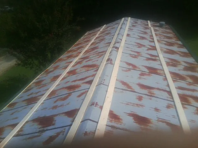Rusted metal roof panels with new wood purlins before replacement — Storm Damage Roof Repair in Cullman by Roofing Brothers