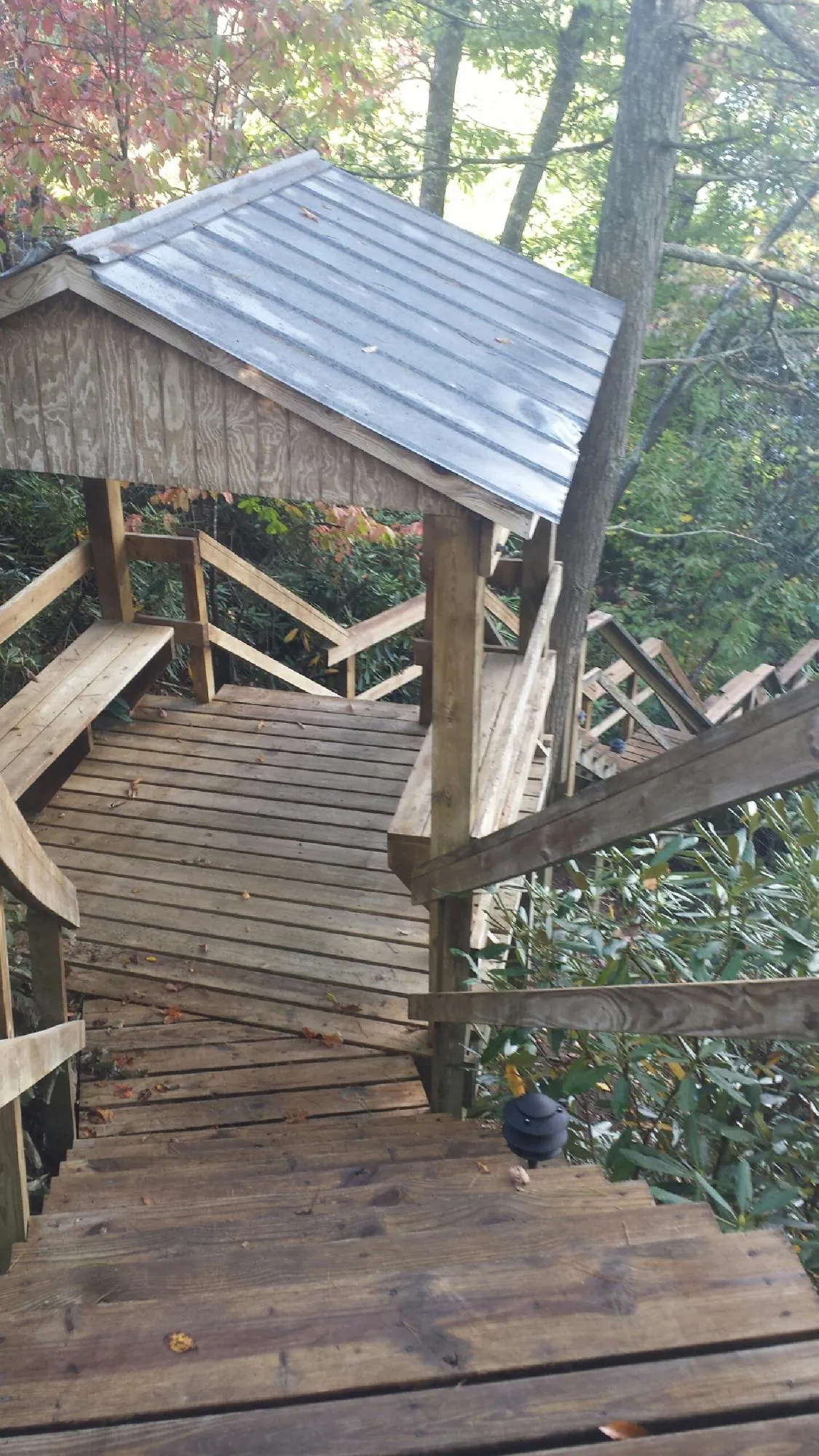 Metal roofed shelter over wooden steps on a wooded walkway — Skylight Repair & Installation work by our crew in Cullman