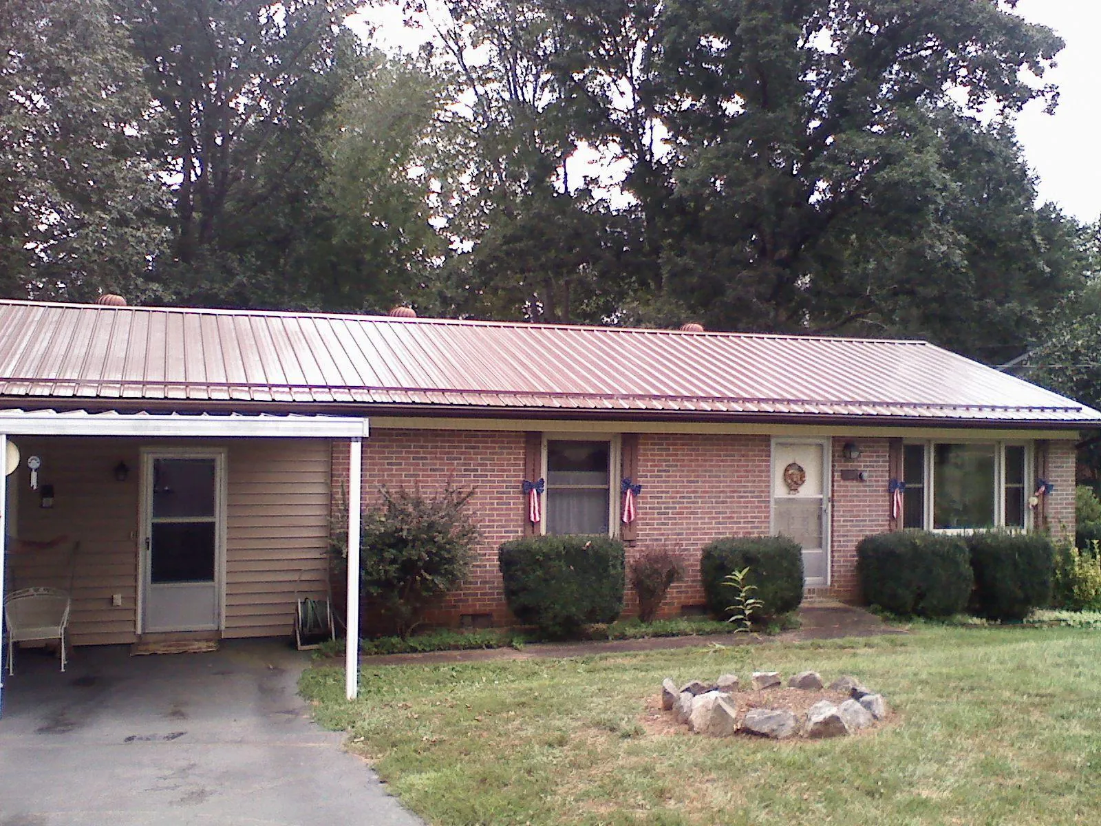 Bronze metal roof and carport on a brick ranch home — Roof Repair work by our crew in Cullman