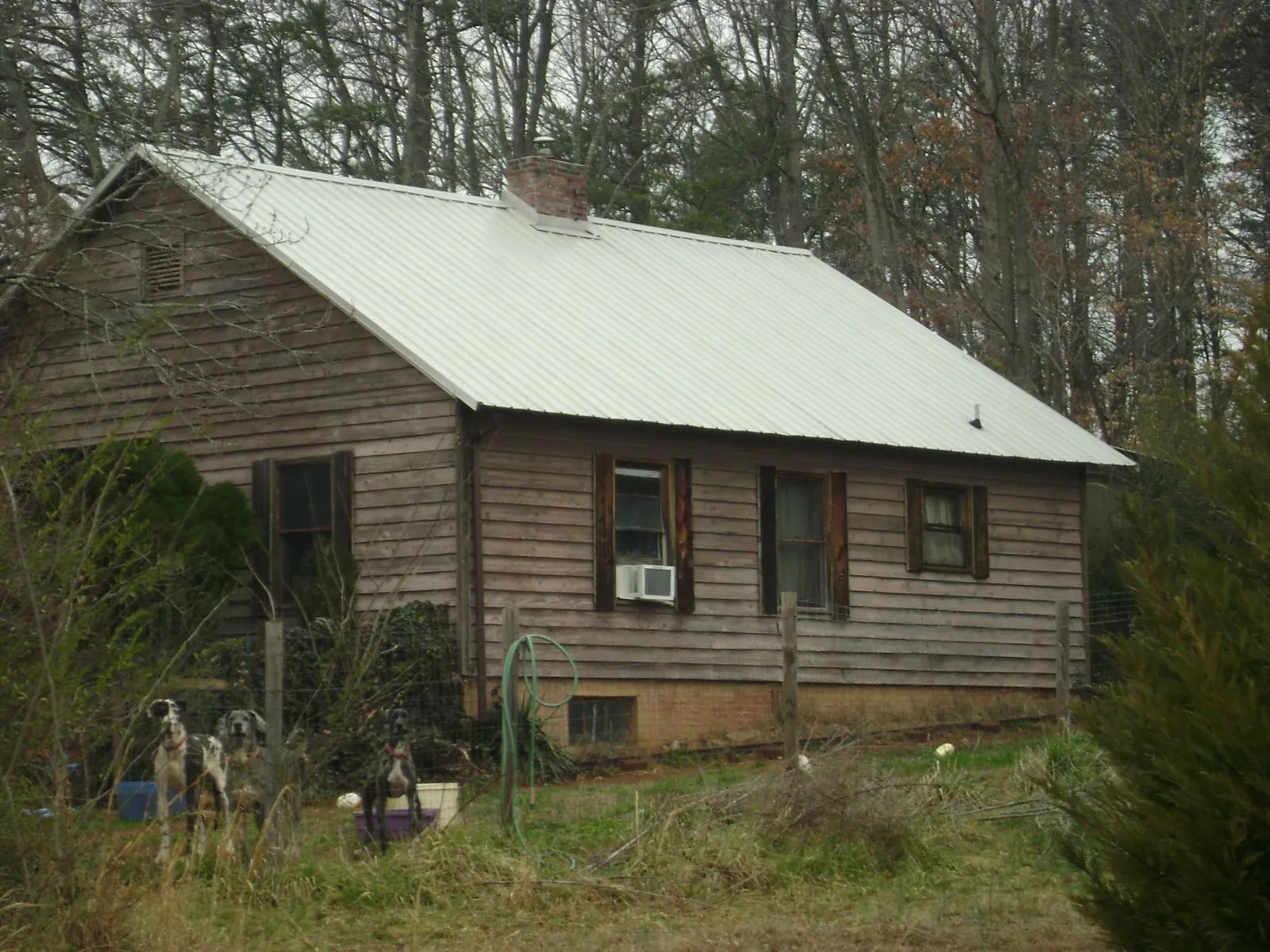 White metal roof on an old wood sided farmhouse, from a Metal Roof Installation job in Cullman